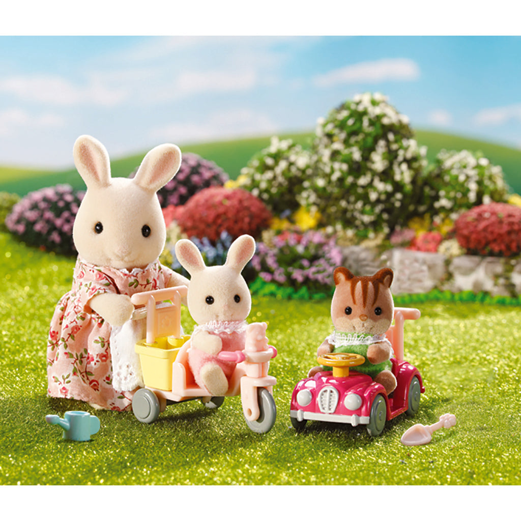 Sylvanian Families dyr med trehjulet cykel og gåbil på grøn mark