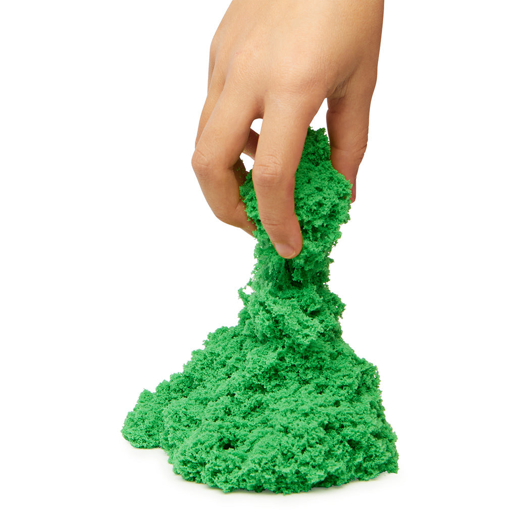 Hånd holder og former grønt Kinetic Sand, der strækker sig.