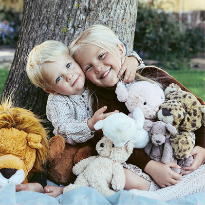 To børn med bløde Jellycat bamser, en kanin, leopard, og løve bamse