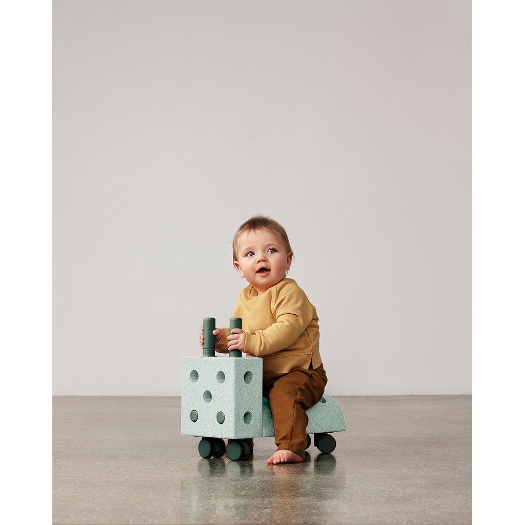Baby sidder på Modu Tiny Ride aktivitetslegetøj i mint og grøn